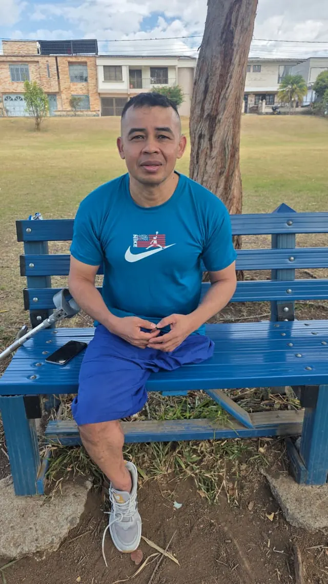 Portrait of Nando seated on a park bench