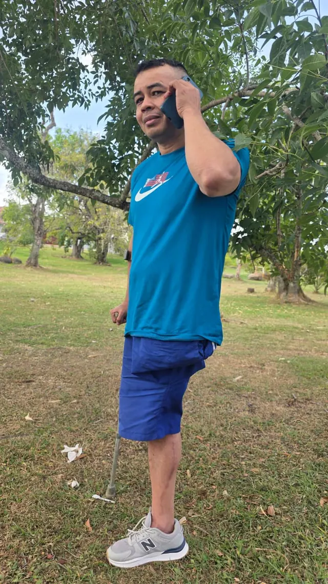 Side view of Nando using a mobility aid